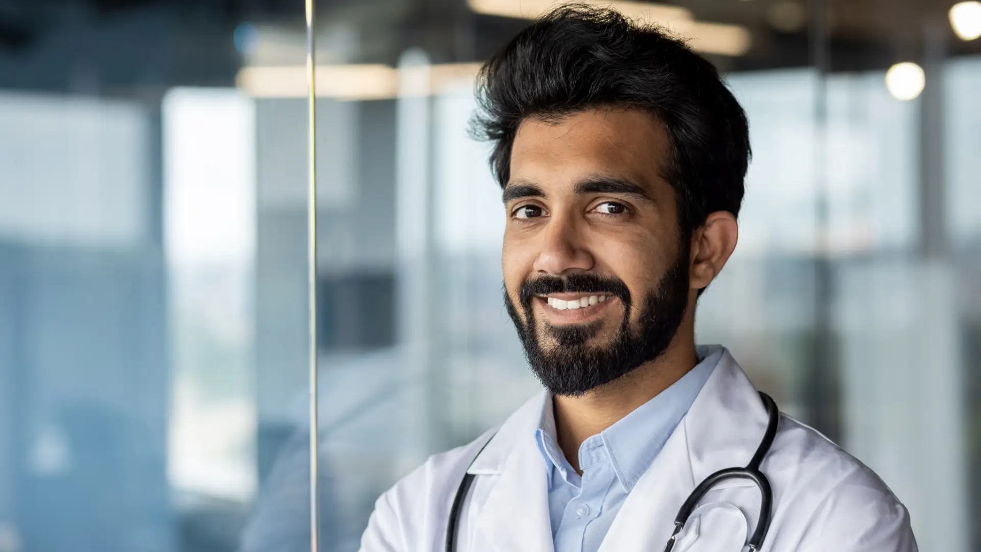 Médico sonriendo en primer plano con un fondo desenfocado